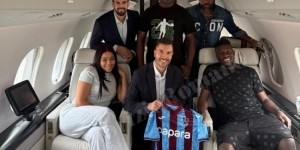 半岛体育-奥纳纳与家人、经纪人在飞机上合影，展示特拉布宗体育球衣